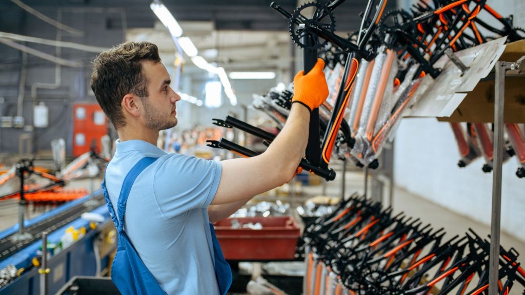 a worker placing a bike frame on a rack