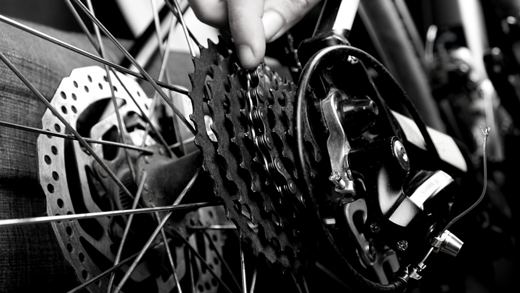 Close up view of a man's hand putting a bike chain back on