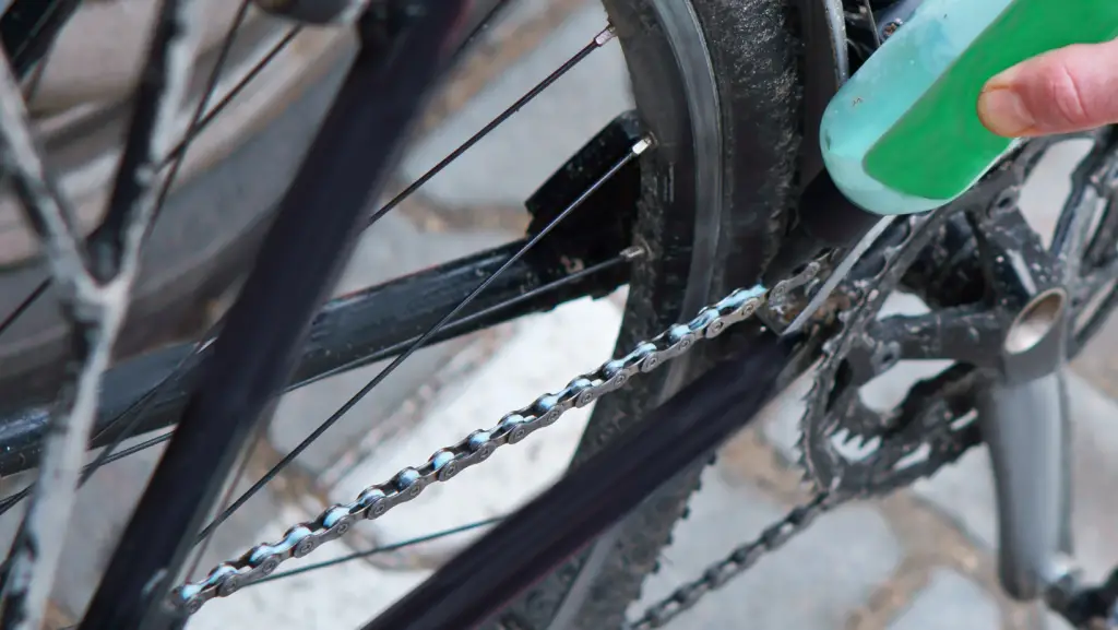 Close up view of someone applying lube on his bike chain