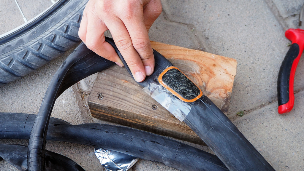 A person repairing a punctured inner tube